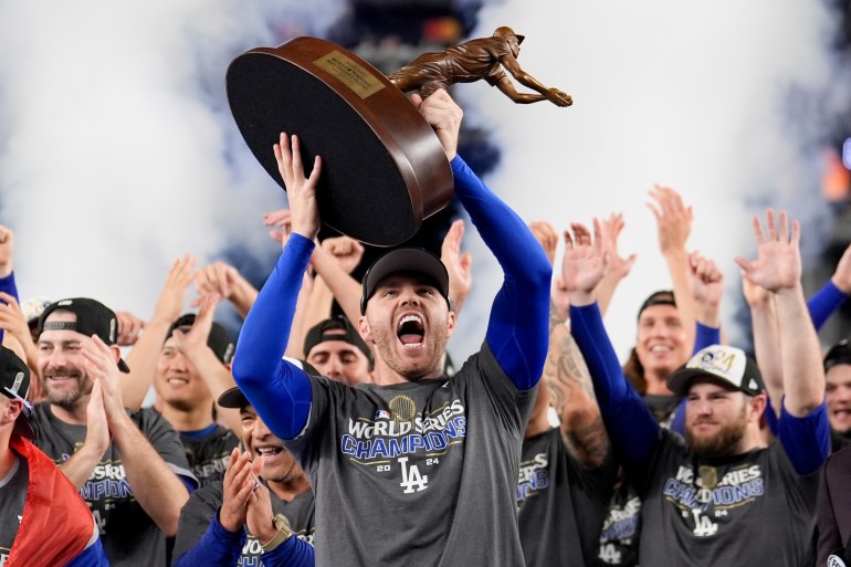 Los Angeles Dodgers' Freddie Freeman celebrates with the MVP trophy after their Game 5 victory over the New York Yankees to win baseball's World Series, Thursday, Oct. 31, 2024, in New York. (AP Photo/Ashley Landis)